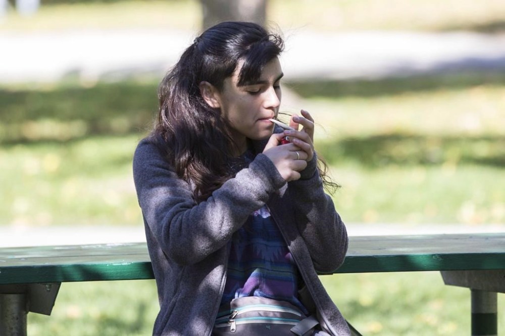 A woman smokes cannabis in a Toronto park on first day of legalization of cannabis across Canada on October 17, 2018. THE CANADIAN PRESS/Chris Young