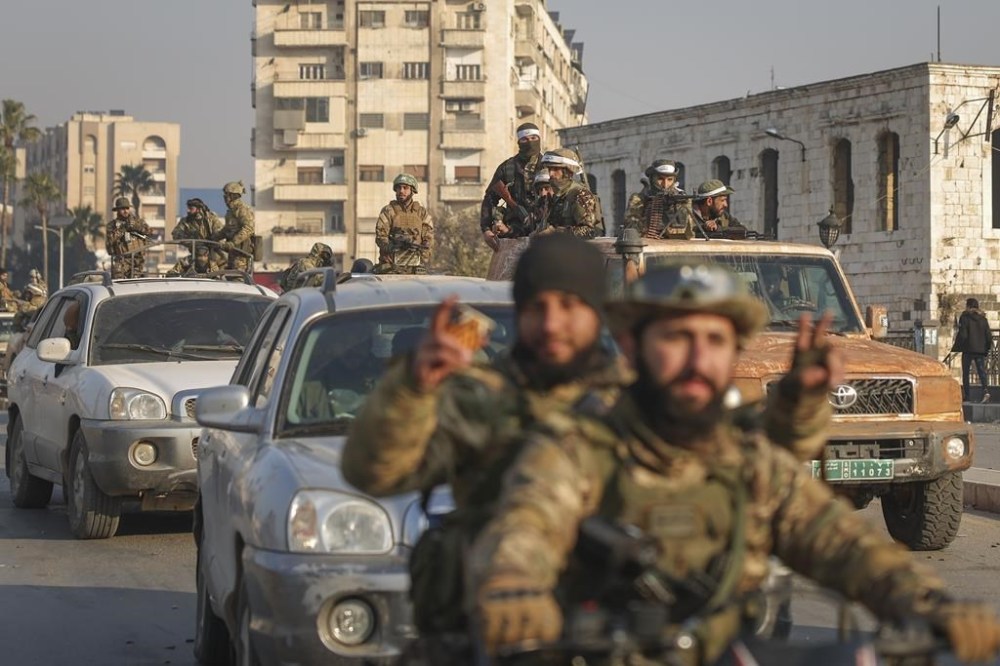 Syrian opposition fighters ride along the streets in the aftermath of the opposition's takeover of Hama, Syria, Friday, Dec. 6, 2024. (AP Photo/Ghaith Alsayed)