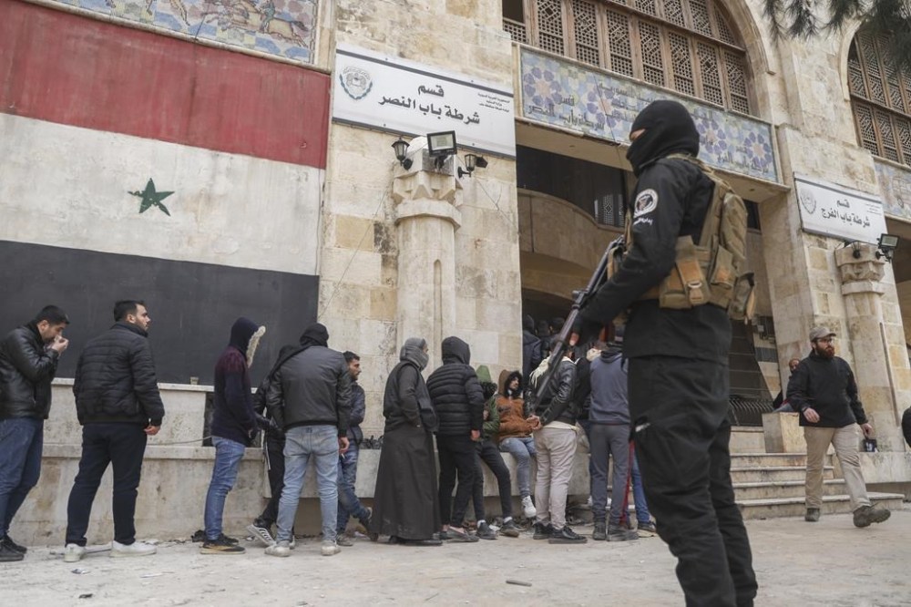 Defectors line-up to register their details with Syrian insurgents in Aleppo, Syria, Thursday Dec. 5, 2024. As insurgents consolidate their hold of Aleppo, which they overran last week, they issued a call to government soldiers and security agencies to defect, granting them what they called