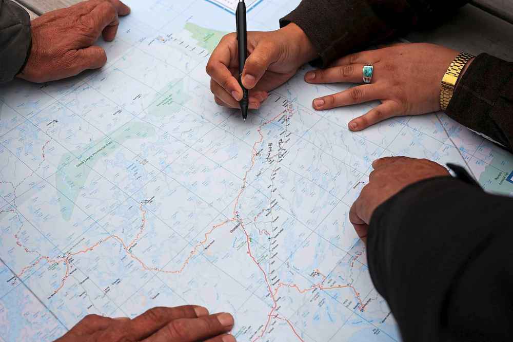 Local hunters look over a map of northeastern Manitoba at the Fox Lake Cree Nation Culture Camp. The Churchill River diversion affected fish and animal movement in the area says former Tataskweyak Cree Nation councillor Robert Spence. (Tim Smith / The Narwhal)