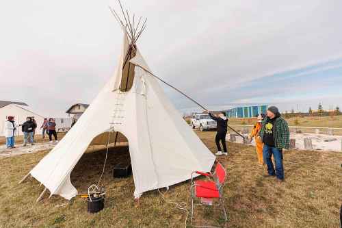 MIKE DEAL / FREE PRESS
Maples Collegiate student, Colby Chartrand-McCorrister, 15, is given direction by Joe Lanceley (right) on installing a smoke flap pole.
Indigenous youth from Maples Collegiate learn to put up and take down a tipi Thursday morning at Ozhaawashkwaa Animikii-Bineshi Aki Onji Kinimaagae’ Inun, Seven Oaks School Division’s land-based learning centre.
There’s ever-growing demand for land-based learning and recognition of their important place across the province's public school system. Teachers have increasingly sought elders’ expertise and planned field trips to sites such as Ozhaawashkwaa Animikii-Bineshi Aki Onji Kinimaagae’ Inun (Blue Thunderbird Land-based Teachings Learning Centre), also known as the Aki Centre. The Aki Centre spans 50 acres, much of which is undergoing restoration so the over-farmed grounds return to their original state as a tallgrass prairie and wetland, in West St. Paul. The Seven Oaks School Division has facilitated rabbit snaring, moose and deer hyde tanning, and the harvesting of sage, sweetgrass and tobacco, since opening it in 2019. More than 5,000 visitors stopped by the Grassmere Road site that houses vegetable and medicine gardens, a sweat lodge and a greenhouse in 2023-24. In doing so, they learned about ecosystems, treaties, conservation and other related topics.
Reporter: Maggie Macintosh
241031 - Thursday, October 31, 2024.