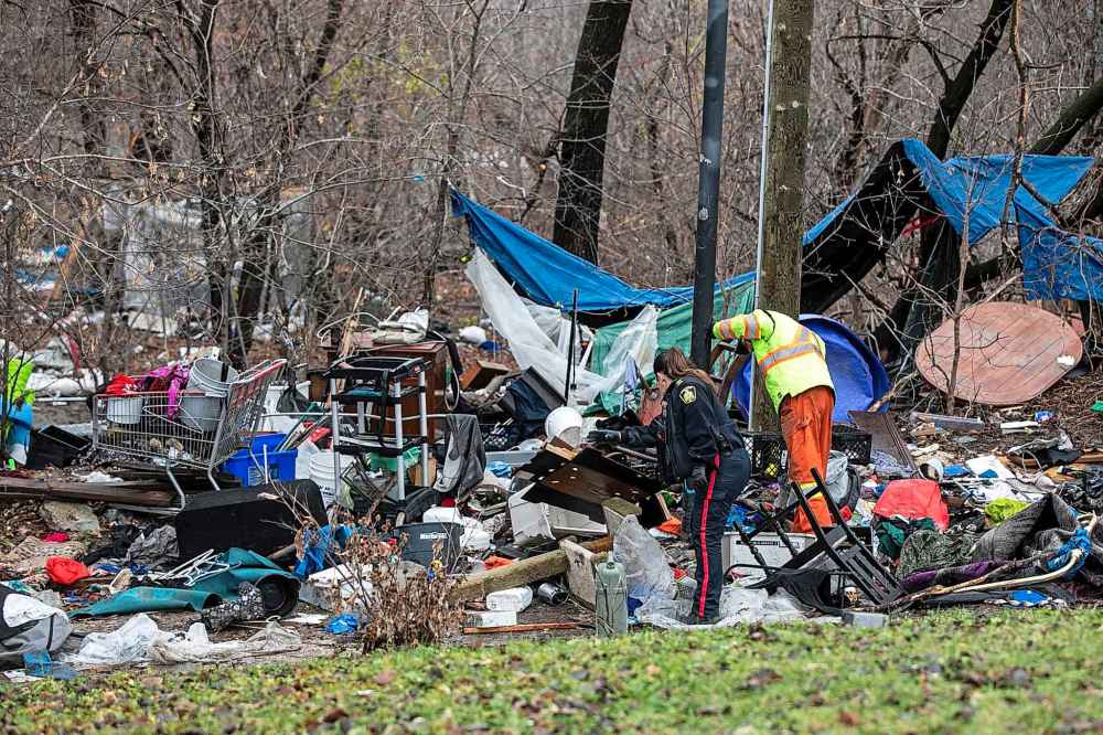 MIKAELA MACKENZIE / FREE PRESS
Police and city workers at an encampment at Mostyn Place Park, where residents were clearing out on Wednesday.