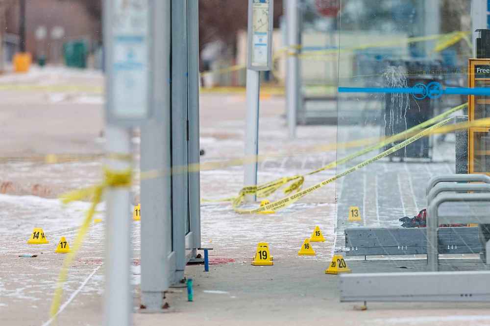 Police take and markers are seen at a Portage Avenue bus stop where an officer-involved shooting occurred took place Sunday evening. (Mike Deal / Free Press)