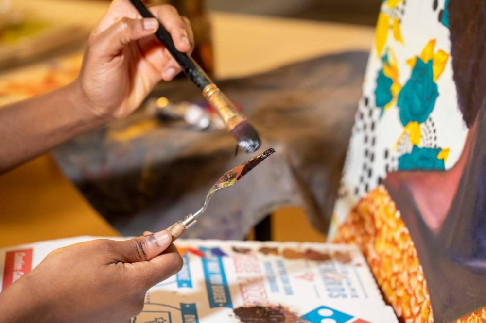 BROOK JONES / FREE PRESS
Ogboru works with a paint brush and palette knife in her home studio.