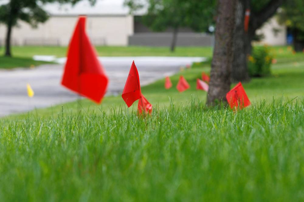 MIKE DEAL / FREE PRESS
                                Utility flags dot homeowners’ yards in July prior to the start of street repair on Augusta Drive near Arthur A. Leach Junior High School.