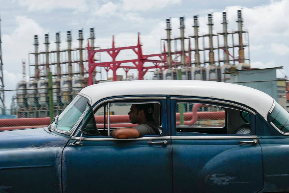 Ramon Espinosa / The Associated Press
On Oct. 18, a classic American car passes a floating generating station that had not been producing electricity for days in Havana
