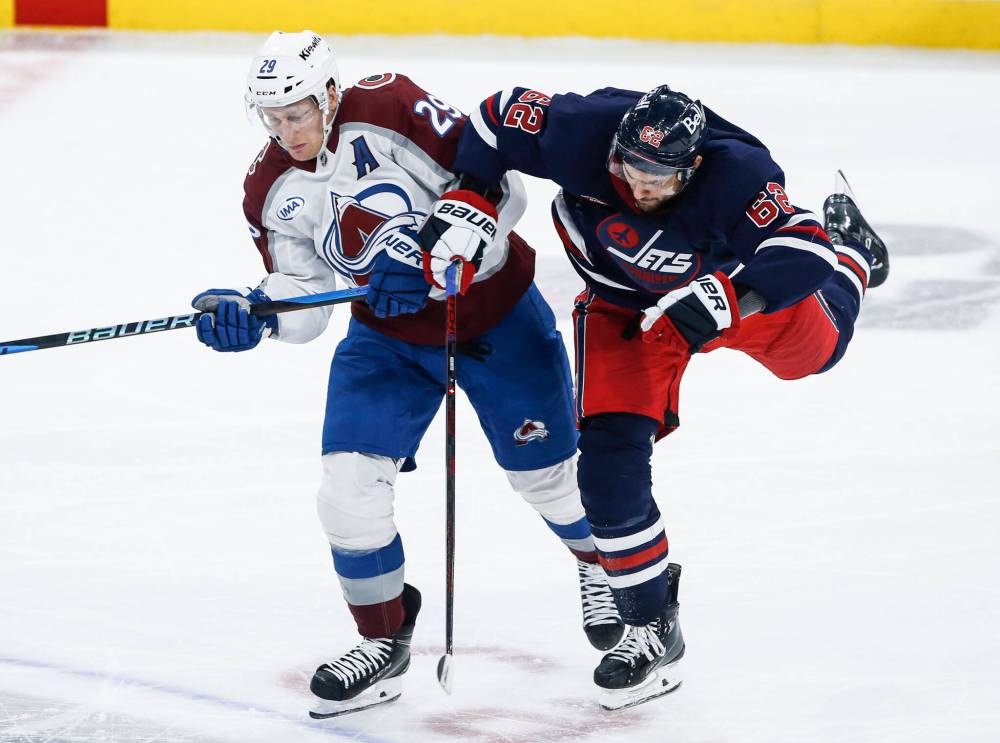 JOHN WOODS / THE CANADIAN PRESS
Winnipeg Jets’ Nino Niederreiter and Colorado Avalanche’s Nathan MacKinnon collide during the third period Thursday night.