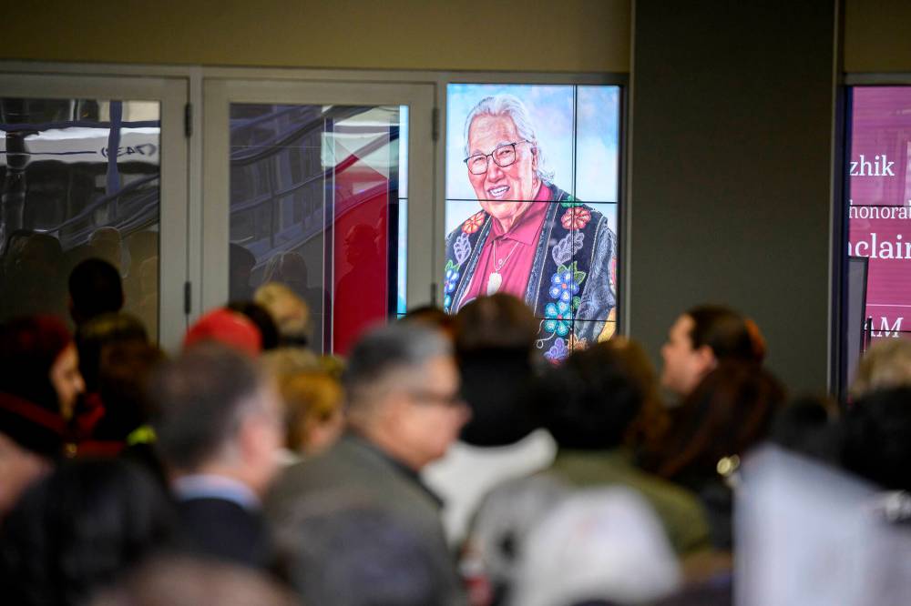 A projection lights up a window Sunday as a crowd waits at the entrance to a memorial service for the late Murray Sinclair held at Canada Life Centre in Winnipeg, Sunday Nov. 10, 2024. (Mike Sudoma / The Canadian Press)