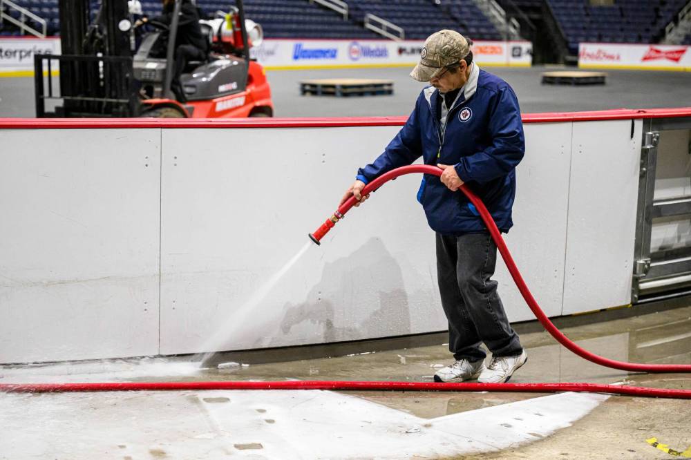 MIKE SUDOMA / FREE PRESS 
                                Lloyd Cook melts ice outside the boards prior to their removal.