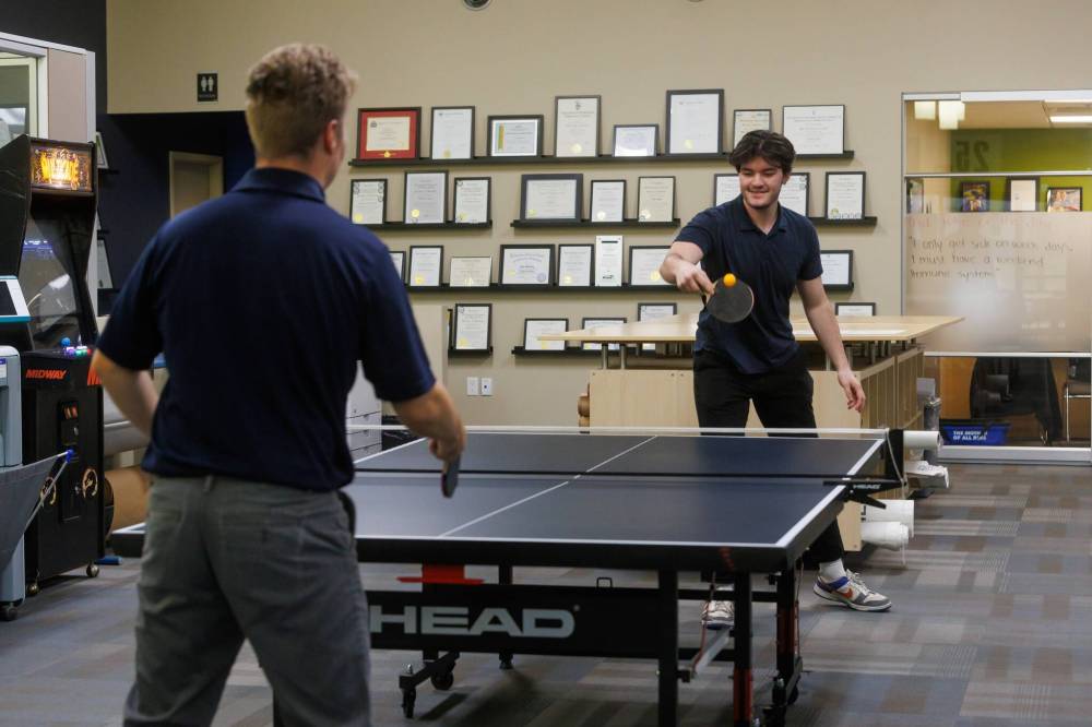 MIKE DEAL / FREE PRESS
Noah Shotton (right) a drafter with Tower Engineering, plays a game of ping pong with engineer-in-training Tyson Nelson during a break.