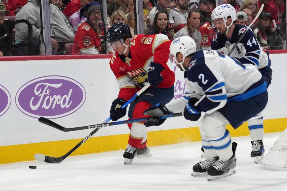Lynne Sladky / The Associated Press
Florida Panthers right wing Mackie Samoskevich and Winnipeg Jets defenceman Dylan DeMelo vie for the puck during the second period.