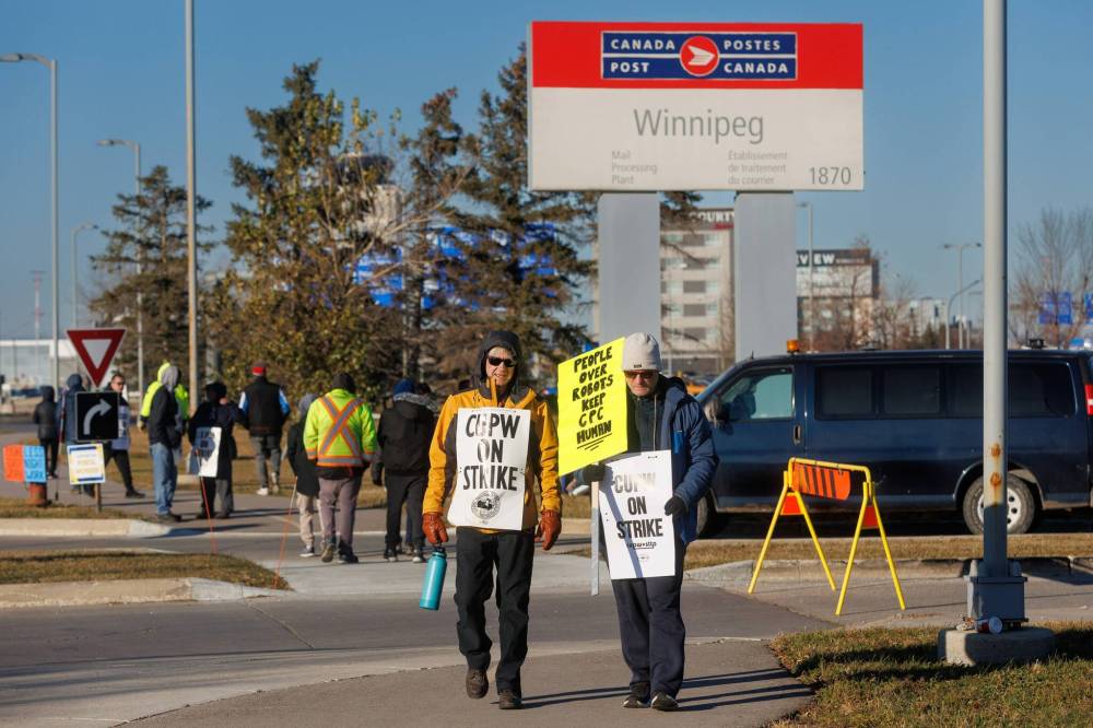 MIKE DEAL / FREE PRESS FILESCanada Post employees walk a picket line outside the main sorting facility in Winnipeg in November. Workers might go on strike again Friday.