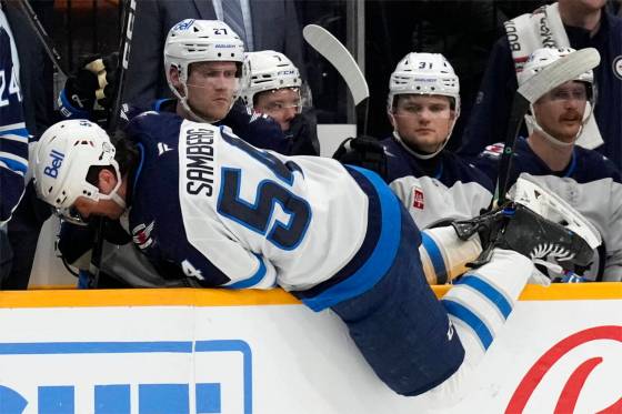 Winnipeg Jets defenceman Dylan Samberg (54) climbs over the boards and onto the bench after being injured in Saturday’s game against the Nashville Predators. (Mark Humphrey/Associated Press files)