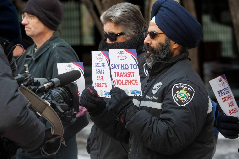 MIKE DEAL / FREE PRESS
Transit driver Mandeep Singh, with signs that read “Secure Seats Safe Streets,” and “Say No to Transit Violence,” participates in the Tuesday rally.