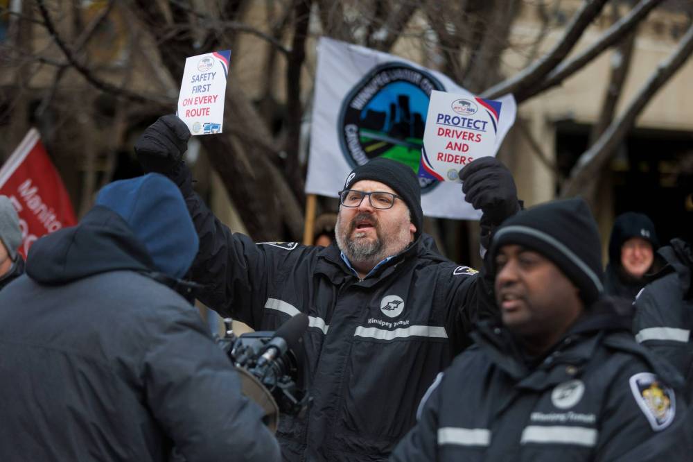 MIKE DEAL / FREE PRESS
Transit driver Christian Brambilla waves signs during the rally, which called for a new incident reporting system for bus drivers, improved safety shields, and more transit safety officers.