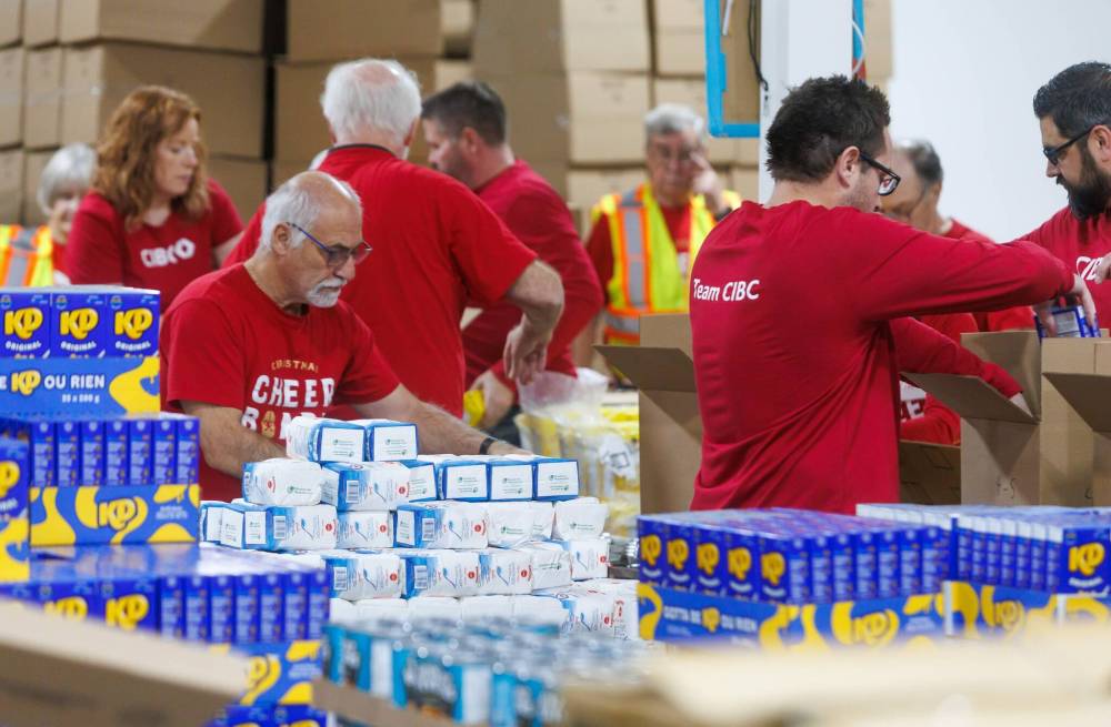 MIKE DEAL / FREE PRESS
Volunteers from CIBC pack up food hampers for The Christmas Cheer Board on Friday afternoon.
