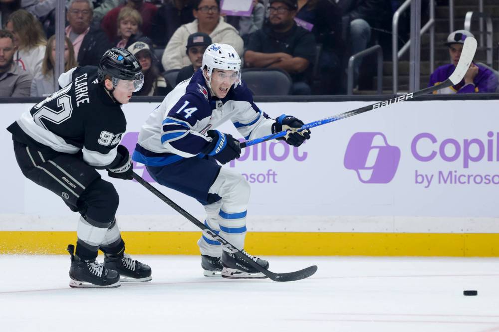 Winnipeg Jets defenceman Ville Heinola, right, and Los Angeles Kings defenceman Brandt Clarke chase the puck during the first period Wednesday in Los Angeles. (AP Photo/Ryan Sun)