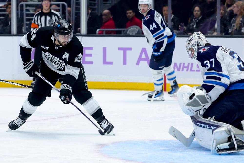 Los Angeles Kings centreman Phillip Danault, left, shoots on Winnipeg Jets goaltender Connor Hellebuyck in the second period. (AP Photo/Ryan Sun)