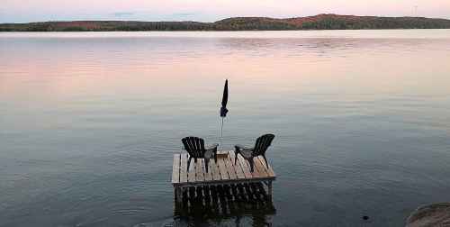Muskoka chairs sit on a dock looking over Boshkung Lake, in Algonquin Highlands, Ont., Monday, Oct. 5, 2020. THE CANADIAN PRESS/Giordano Ciampini