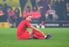 Bayern's Harry Kane sits on the pitch after getting injured during the German Bundesliga soccer match between Borussia Dortmund and Bayern Munich at the Signal-Iduna Park in Dortmund, Germany, Saturday, Nov. 30, 2024. (Federico Gambarini/dpa/dpa via AP)