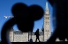 A man is silhouetted as buildings cast their shadows in front of the Peace tower on Parliament Hill, in Ottawa, Wednesday, Nov. 27, 2024. THE CANADIAN PRESS/Adrian Wyld