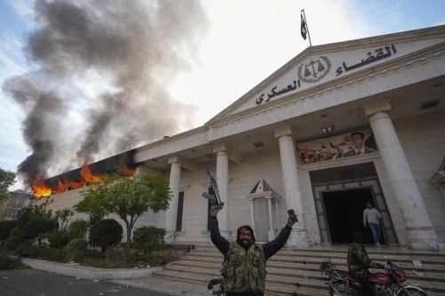Ottawa is urging Canadians to avoid all travel to Syria and to consider leaving the country if it's safe to do so. Opposition fighters celebrate as they burn down a military court in Damascus, Syria, Sunday, Dec. 8, 2024. THE CANADIAN PRESS/AP-Hussein Malla