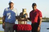 Scottie Scheffler, left, of the United States, and Tiger Woods, right, pose with the championship trophy after the final round of the Hero World Challenge PGA Tour at the Albany Golf Club in New Providence, Bahamas, Sunday, Dec. 8, 2024. (AP Photo/Fernando Llano)
