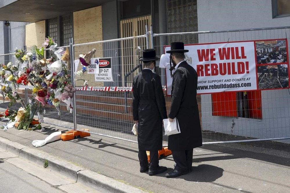 People gather outside the fire damaged Adass Israel Synagogue in Melbourne, Monday, Dec. 9, 2024. (Con Chronis/AAP Image via AP)
