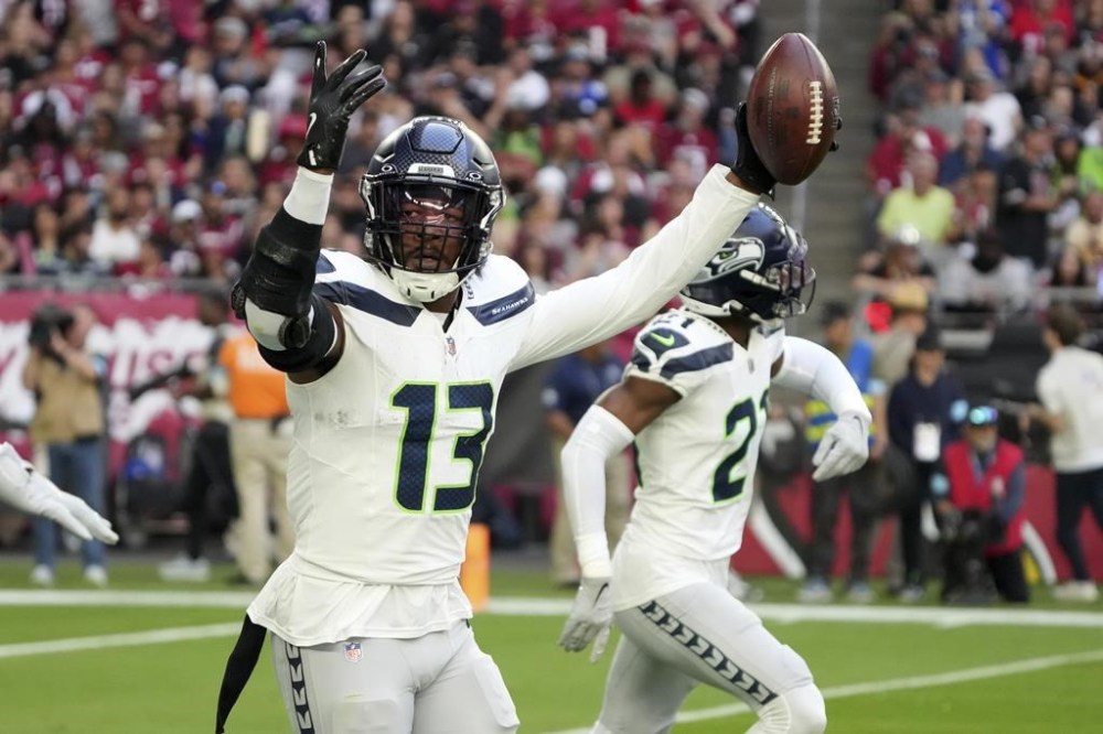 Seattle Seahawks linebacker Ernest Jones IV (13) celebrates his interception against the Arizona Cardinals during the first half of an NFL football game, Sunday, Dec. 8, 2024, in Glendale, Ariz. (AP Photo/Rick Scuteri)