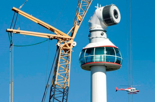 A news helicopter flies by as a 130-ton all-terrain crane prepares to place the giant blades onto a massive wind turbine on the top of Grouse Mountain ski resort in North Vancouver, B.C., Friday, Sept. 25, 2009.  THE CANADIAN PRESS/Jonathan Hayward