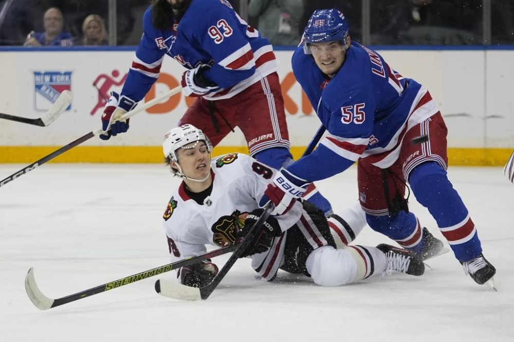 New York Rangers' Ryan Lindgren (55) fights for position with Chicago Blackhawks' Connor Bedard during the first period of an NHL hockey game, Monday, Dec. 9, 2024, in New York. (AP Photo/Frank Franklin II)