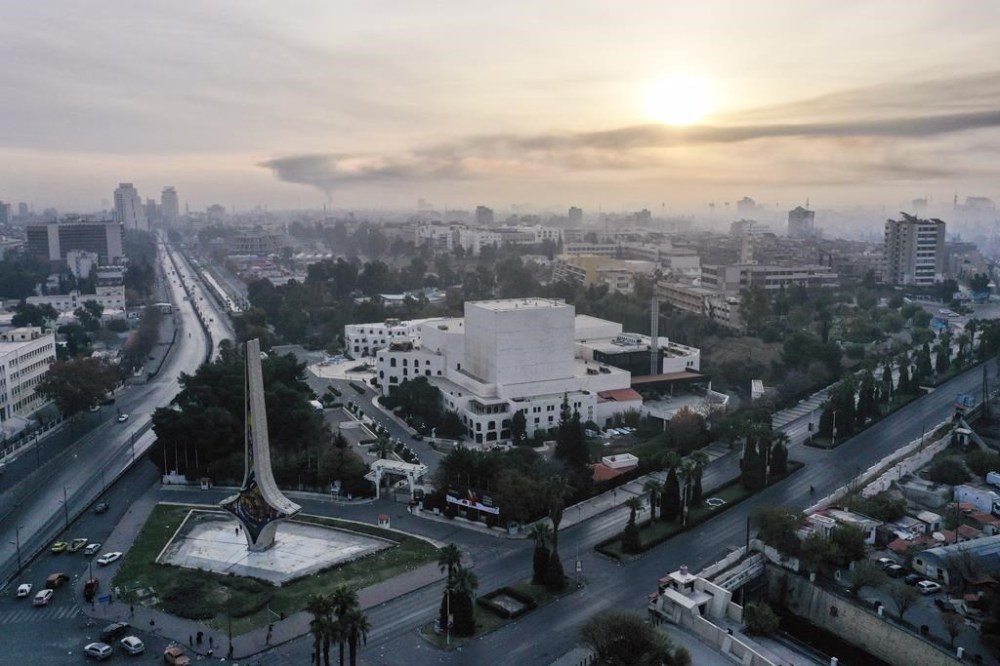 An aerial view shows a column of black smoke in the background, allegedly caused by an Israeli airstrike, as seen from Umayyad square in Damascus, Syria, Tuesday, Dec. 10, 2024.(AP Photo/Ghaith Alsayed)