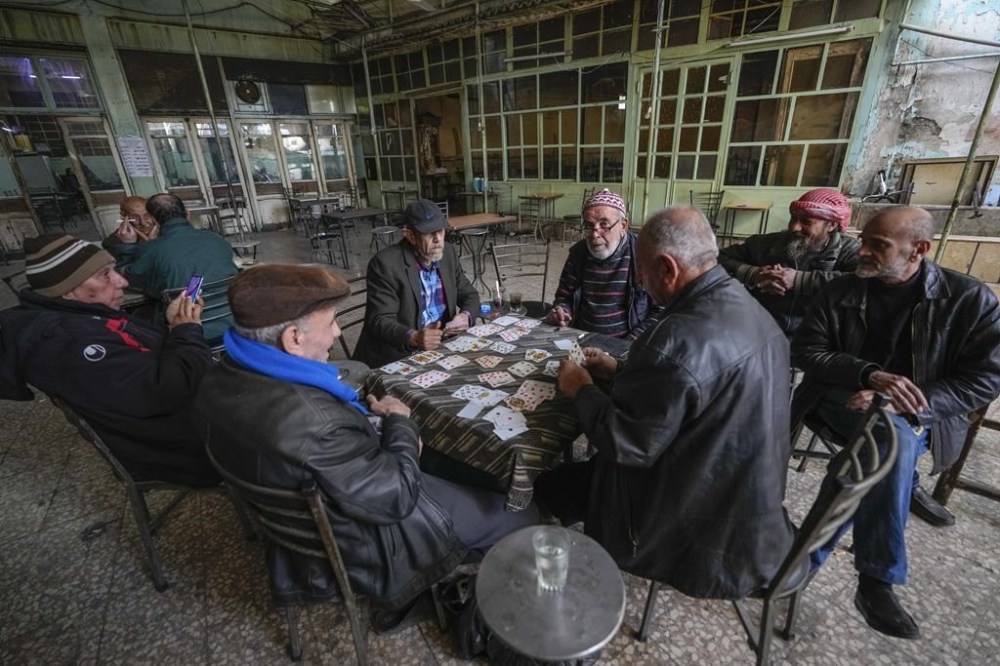 A group of Syrians plays cards at a café in Damascus, Syria, on Tuesday, Dec. 10, 2024. (AP Photo/Hussein Malla)