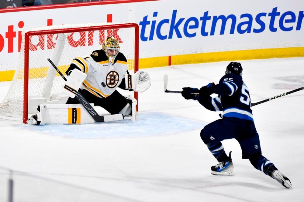 Winnipeg Jets' Mark Scheifele (55) scores on Boston Bruins goaltender Jeremy Swayman (1) during the first period of their NHL hockey game in Winnipeg, Tuesday Dec. 10, 2024. THE CANADIAN PRESS/Fred Greenslade