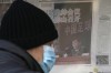 FILE - A man looks at a kiosk displaying a newspaper with a photo of Chen Xuyuan, head of the Chinese Football Association, in Beijing, Wednesday, Feb. 15, 2023. (AP Photo/Andy Wong, File)