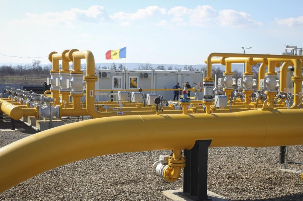 FILE - Men stand next to pipelines of the national natural gas distribution network outside Ungheni, Moldova, March 4, 2015. (AP Photo/Aurel Obreja)