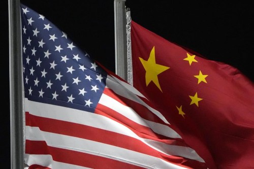 FILE - The American and Chinese flags wave at Genting Snow Park ahead of the 2022 Winter Olympics, in Zhangjiakou, China, Feb. 2, 2022. (AP Photo/Kiichiro Sato, File)