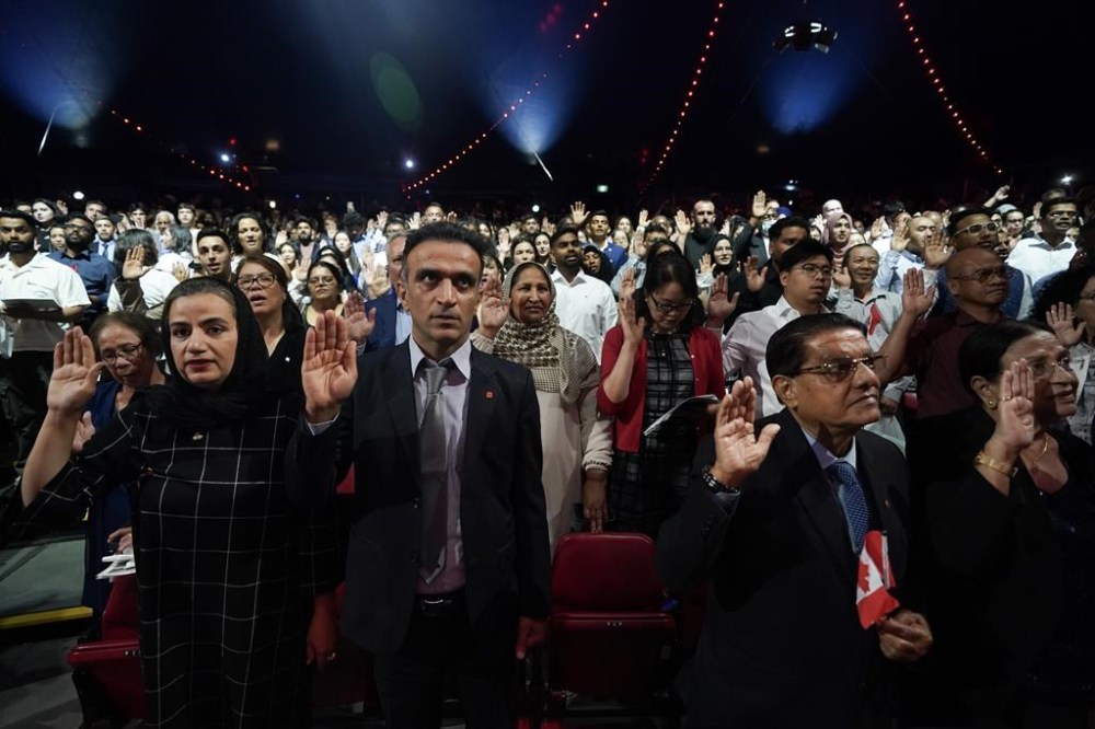 Some of the nearly 400 new Canadians from 65 countries take an oath of citizenship at a ceremony in Toronto on July 19, 2024. As the federal government looks to drastically reduce its immigration targets over the next few years, the mayors of northern Ontario's largest cities say they need more immigrants to sustain local economies and population. THE CANADIAN PRESS/Chris Young