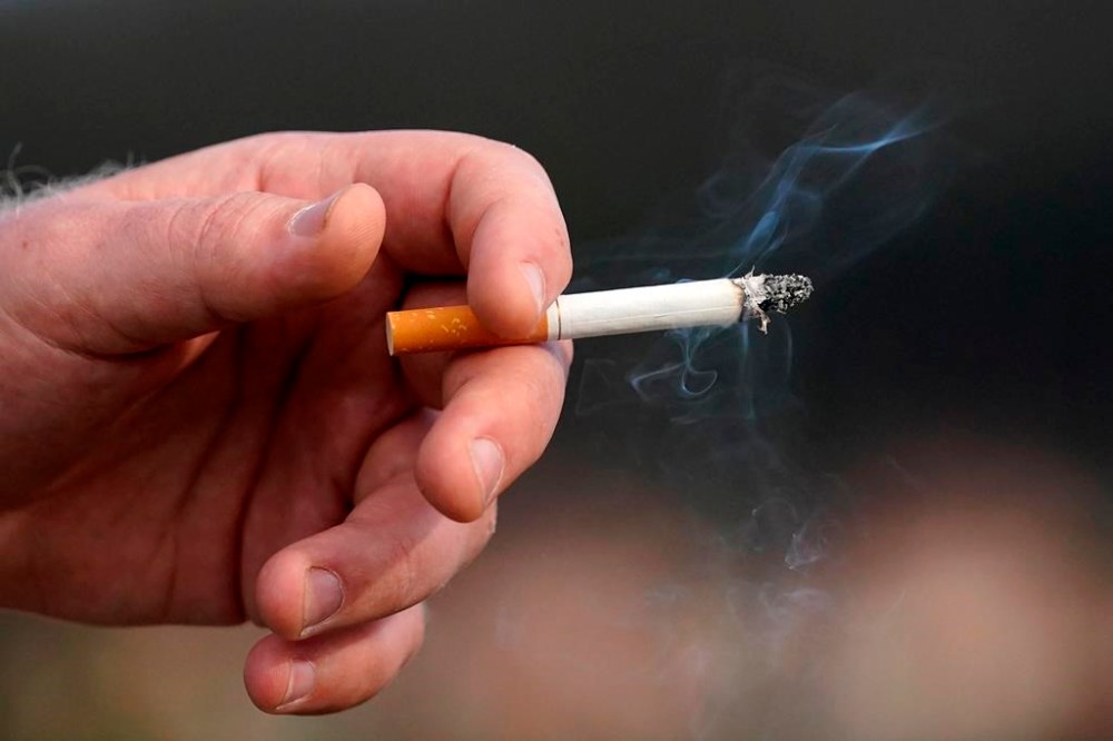 A man holds a lit cigarette while smoking in San Francisco, Wednesday, Dec. 2, 2020. THE CANADIAN PRESS/AP-Jeff Chiu