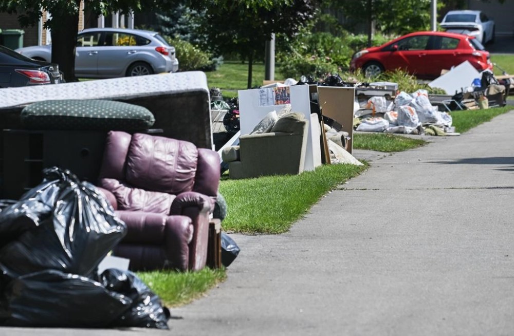 Discarded furniture and other household belongings are shown on a street in Beaconsfield west of Montreal, Tuesday, August 13, 2024, following a storm that dumped up to 175 millimetres of rain on Montreal and across other regions of the province. THE CANADIAN PRESS/Graham Hughes