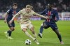Salzburg's Mads Bidstrup, left, and PSG's Nuno Mendes battle for the ball during a Champions League opening phase soccer match in Salzburg, Austria, Tuesday, Dec. 10, 2024.(AP Photo/Matthias Schrader)