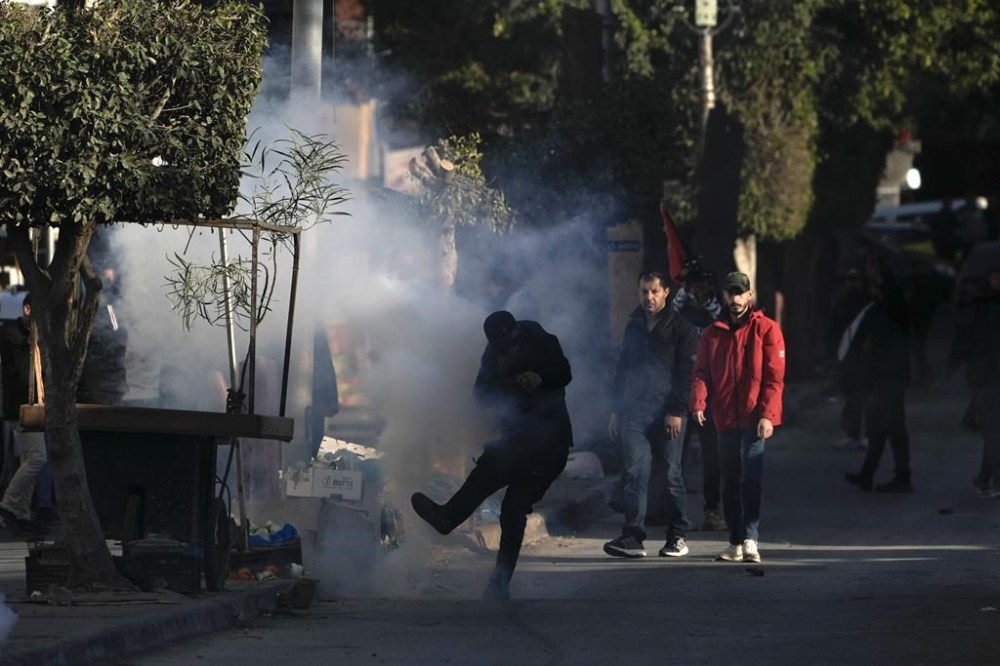 Palestinian youth clash with Palestinian security forces on the third day of a raid, outside the Jenin refugee camp in the Israeli-occupied West Bank, Monday, Dec. 16, 2024.(AP Photo/Majdi Mohammed).