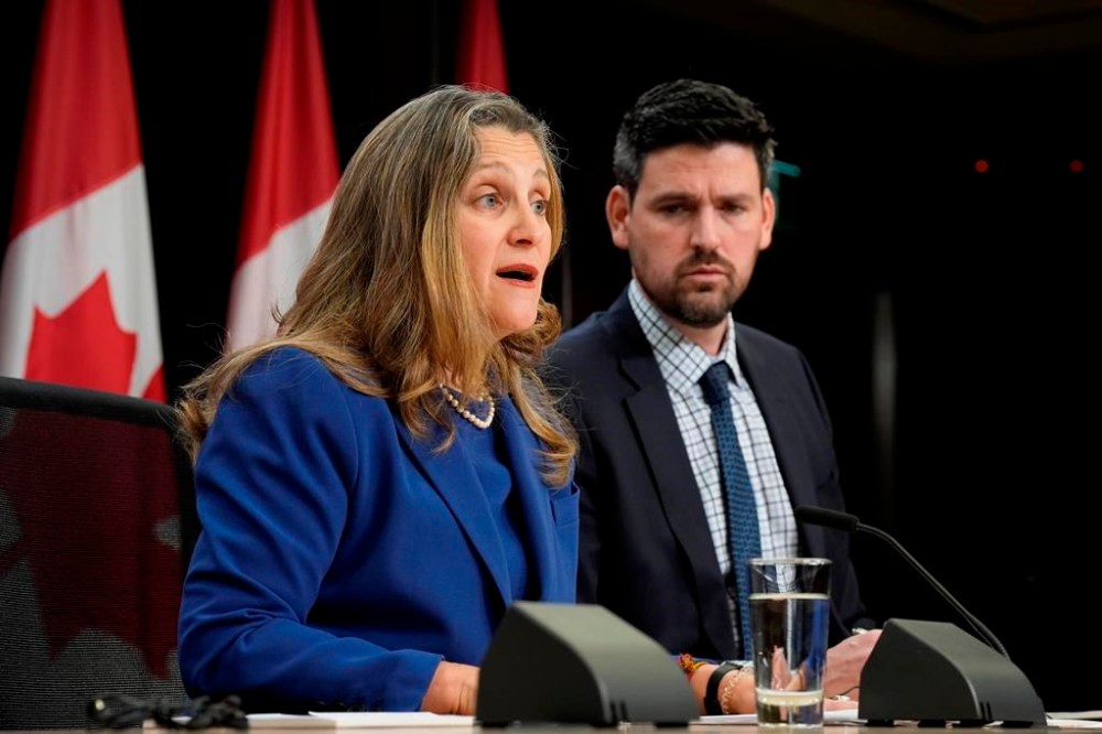 Minister of Housing, Infrastructure and Communities Sean Fraser listens to Deputy Prime Minister and Finance Minister Chrystia Freeland speak during a news conference, Tuesday, Dec. 10, 2024. THE CANADIAN PRESS/Adrian Wyld