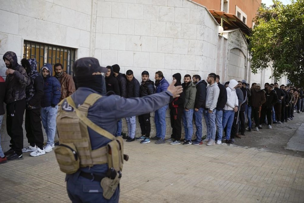 Members from Bashar Assad's Syrian army period line up to register with Syrian rebels as part of a