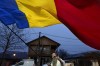 A man waves the Romanian flag outside the closed voting station where Calin Georgescu, an independent candidate for president who won the first round of presidential elections, was supposed to vote, after Romania's Constitutional Court annulled the first round of presidential elections, in Mogosoaia, Romania, Sunday, Dec. 8, 2024. (AP Photo/Andreea Alexandru)