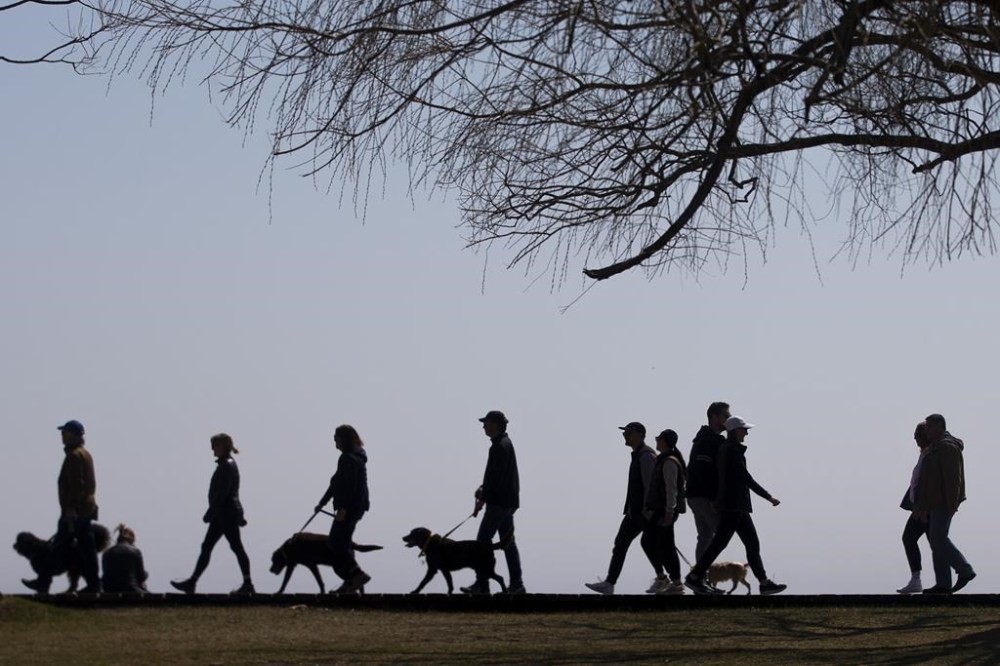 Statistics Canada estimates the population grew by 176,699 people between July 1 and Oct. 1, marking the slowest pace of growth since the first quarter of 2022.
People walk along the boardwalk in Toronto's east end on Sunday, April 4 2021. THE CANADIAN PRESS/Chris Young