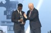 FIFA president Gianni Infantino, right, hugs Vinicius Junior of Real Madrid as he is awarded as the Best Men's FIFA Player during the FIFA Football Awards 2024 in Doha, Qatar, Tuesday, Dec. 17, 2024. (AP Photo/Hussein Sayed)
