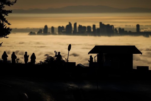 People are silhouetted as they view and photograph fog shrouding the Vancouver area, from Cypress Mountain in West Vancouver, B.C., Dec. 3, 2024. THE CANADIAN PRESS/Darryl Dyck
