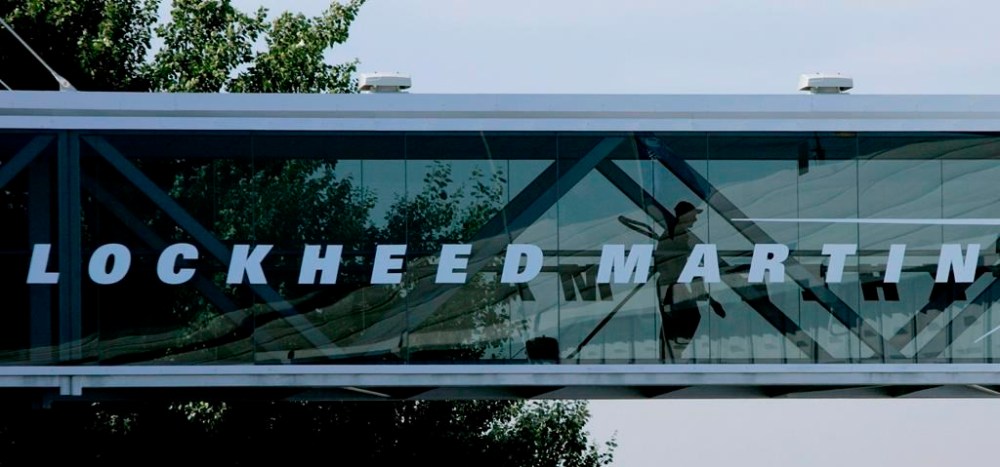 FILE - A man walks past a Lockheed Martin logo as he walks through a section of the company's chalet bridging a road at Farnborough International Airshow in Farnborough, southern England, July 19, 2006. (AP Photo/Matt Dunham, File)
