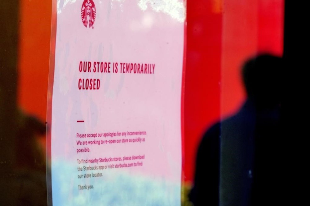 A closed store sign is seen in the window of a Starbucks as workers picket outside the location on company Friday, Dec. 20, 2024, in Burbank, Calif. (AP Photo/Damian Dovarganes)